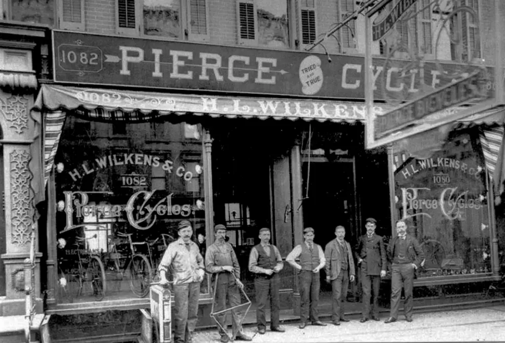 The storefront of H.L. Wilkens & Co., a Pierce Cycles dealer, with staff posed outside.