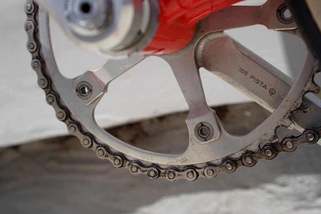 Close view of the back of a polished five-arm Campagnolo track crank and chainring, the arm stamped 165 PISTA followed by the digit 4 inside a small circle