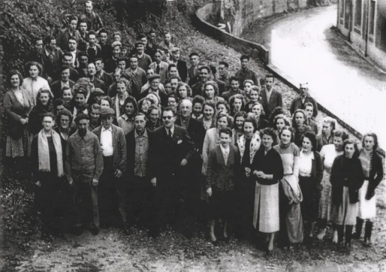 Company photograph of about ninety Idéale staff gathered on the roadside bank after the opening of the works canteen