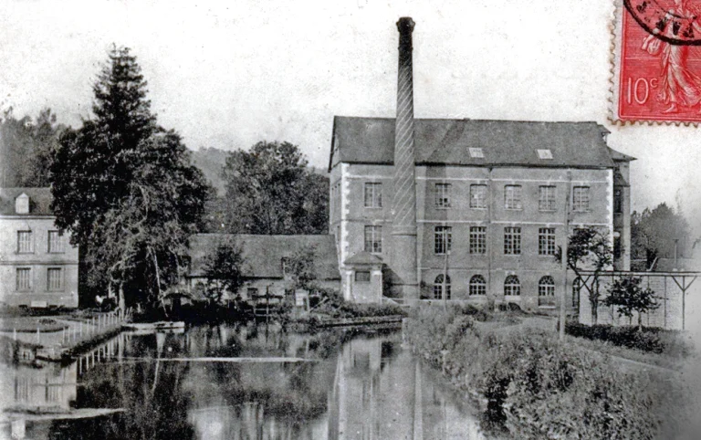 Postcard view of the F. Tron works at Pont-Saint-Pierre seen across the millpond, a tall brick chimney rising beside the three story mill building