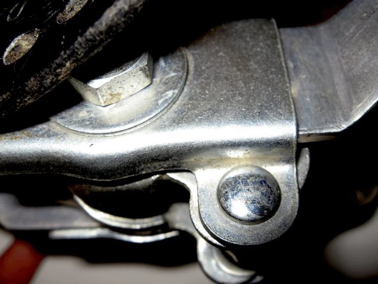 Macro of the Idéale seatpost clamp hardware, its polished alloy jaws and dome headed bolt seen from below