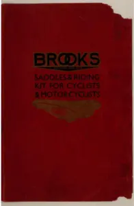 Red card catalog cover printed in black and gold, headed BROOKS above the words SADDLES & RIDING KIT FOR CYCLISTS & MOTOR CYCLISTS, with a gold-blocked sprung leather saddle carrying an oval BROOKS badge beneath the lettering.