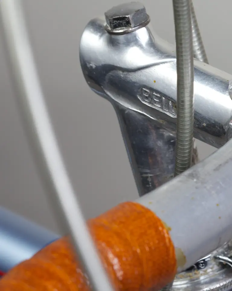 Polished alloy handlebar stem of the 1948 Cycle de France randonneuse, stamped BELL, with the leather-wrapped randonneur handlebar below it