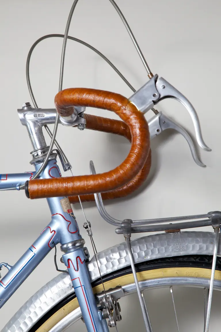 Cockpit of the 1948 Cycle de France randonneuse, showing the leather-wrapped randonneur handlebar, alloy brake levers, the Bell stem and the alloy headlamp carried on the front rack