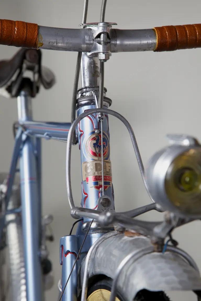 Head badge of the 1948 Cycle de France randonneuse, a Gallic rooster on a tricolore shield reading C.D.F. Cycle de France St Étienne, above a cable hanger stamped Mafac