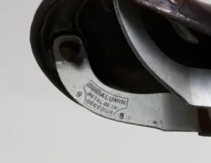 Duralumin undercarriage of the Idéale saddle on the 1948 Cycle de France randonneuse, stamped DURALUMIN MÉTAL DE LA CÉGÉDUR inside a shield and flanked by the numeral 9