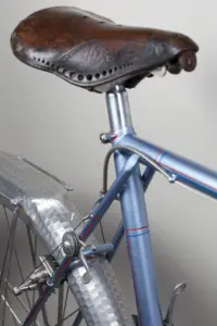 Idéale leather saddle and seat-stay manette of the 1948 Cycle de France randonneuse seen from behind, above the hammered Lefol rear fender