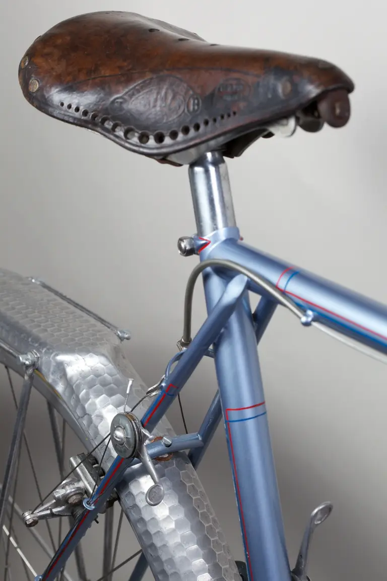 Leather saddle and seat-stay manette of the 1948 Cycle de France randonneuse seen from behind, above the hammered Lefol rear fender