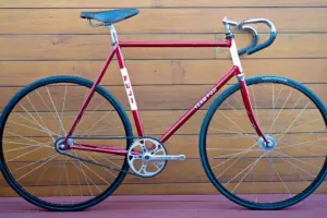 Drive-side profile of a 1970s Team Fuji track bicycle in metallic red with white head tube and seat tube panels, fitted with a Sugino crankset, Araya rims and a Palace leather saddle