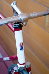 Mount Fuji head badge on the white head tube panel of the Team Fuji, with the Nitto Olympiade stamp and the Fuji laurel engraving on the handlebar above it