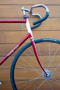 Front quarter view of the Team Fuji head tube, its chrome Nitto track stem and the dropped track handlebar