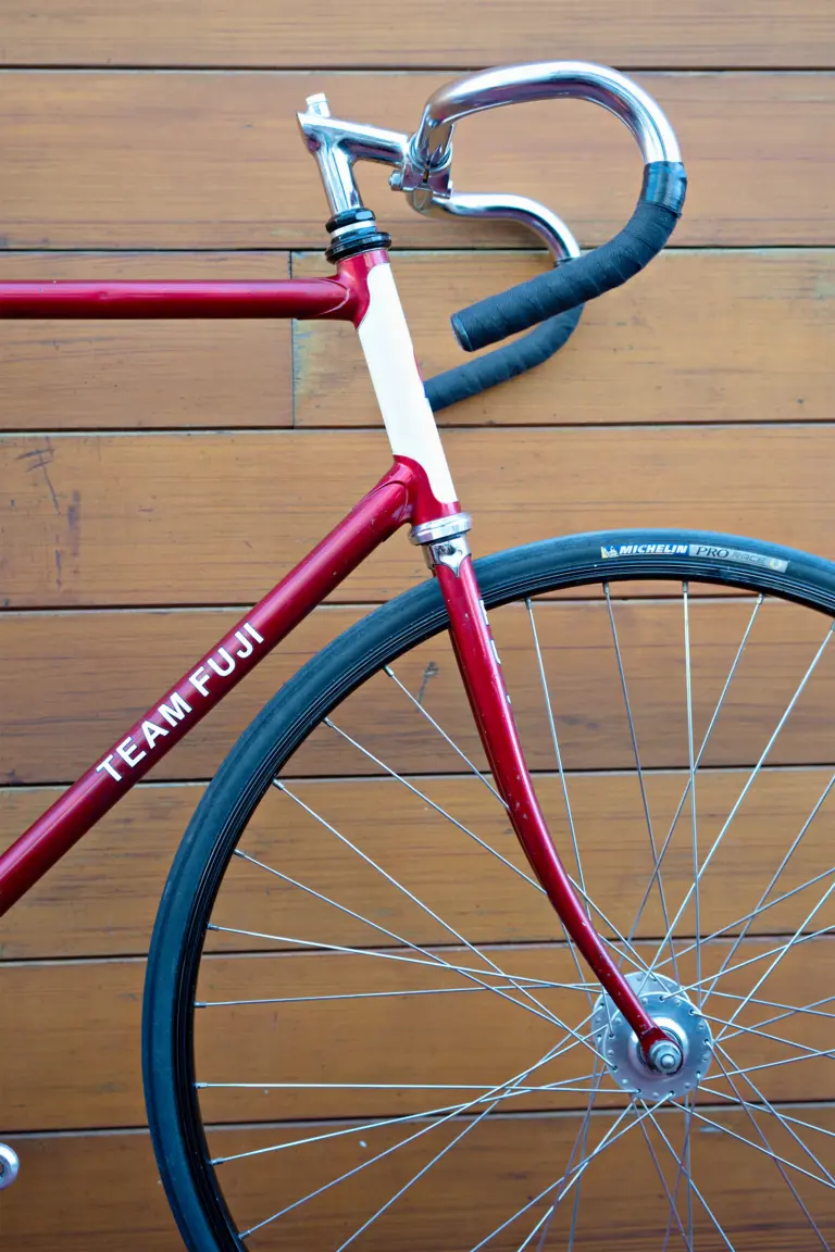 Front quarter view of the Team Fuji head tube, its chrome Nitto track stem and the dropped track handlebar