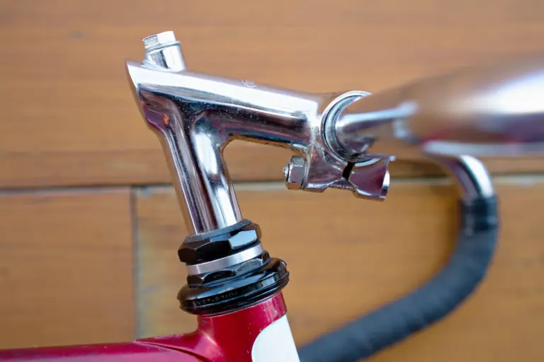 Chrome Nitto track stem and headset of the Team Fuji seen from the side, with the taped handlebar behind