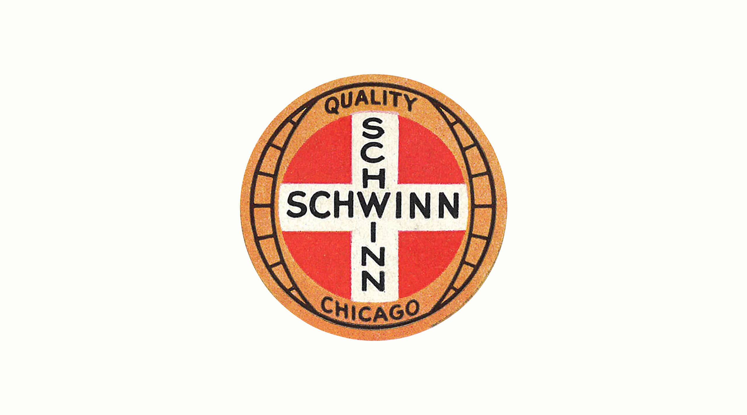 Circular Schwinn badge with a red field, a white cross lettered SCHWINN twice, and a tan outer ring reading QUALITY and CHICAGO, centered on a plain light ground
