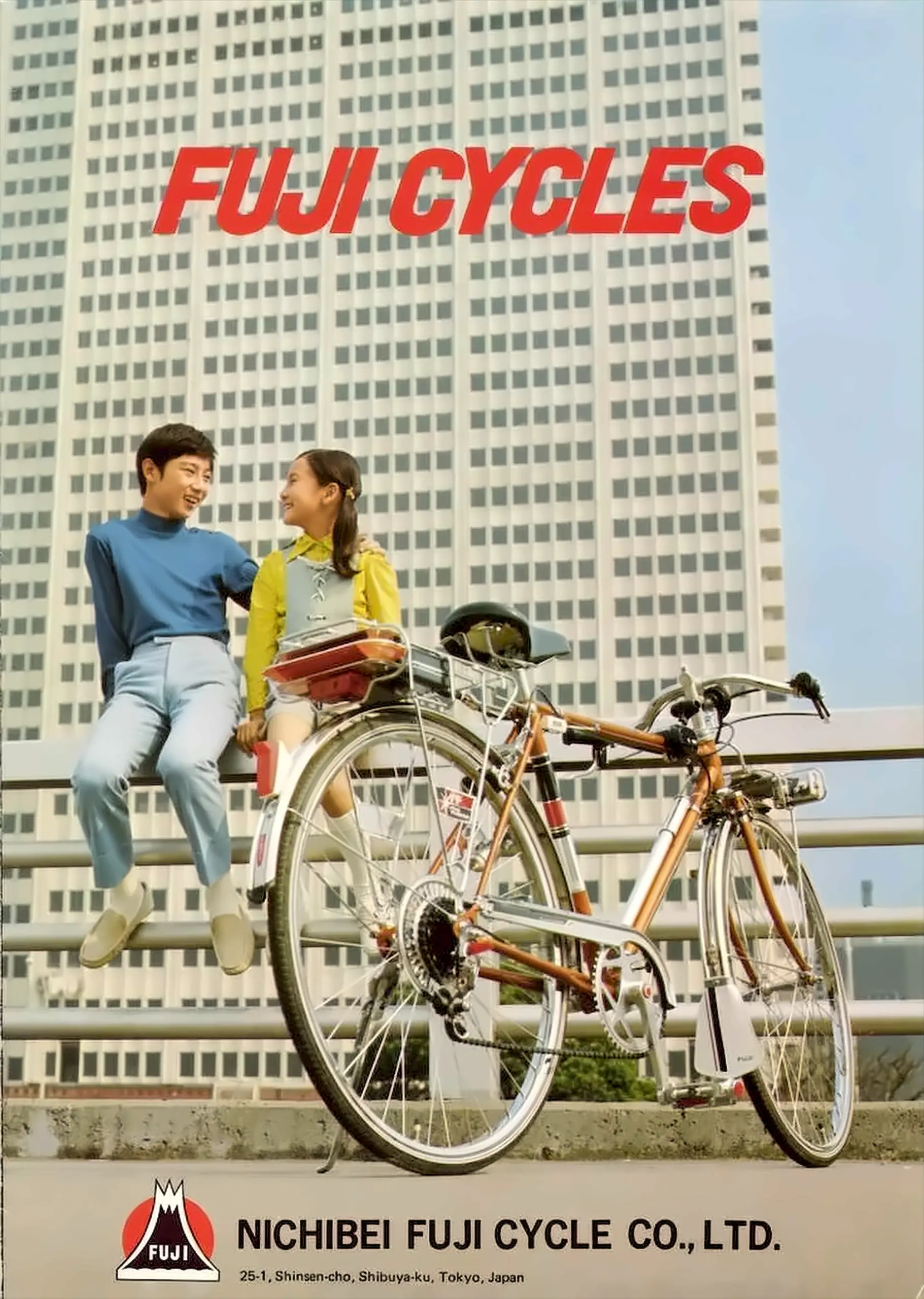Catalog cover photographed against a high-rise office block, two young people seated on a railing beside a Fuji sports bicycle, under the words Fuji Cycles in red