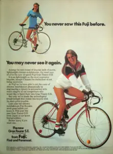 Magazine advertisement headed You never saw this Fuji before. You may never see it again., showing a woman riding a red Fuji Gran Tourer S.E. and a second silver Fuji standing above
