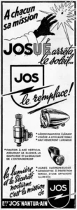 JOS lighting advertisement from Le Cycle, 1956: a gloved hand raised against a startled cartoon sun above the JOS shield crossed by a lightning bolt, with drawings of a visored headlamp, a bottle dynamo and a rear lamp with a reflector.