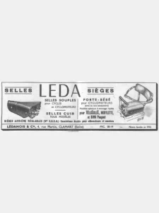Leda advertisement from L'Officiel du cycle, 22 June 1957, page 18: a wide ruled box with a drawing of a sprung leather saddle with a stitched cover and a small oval nose plate at left and a padded child seat with a backrest and side arms clamped to a rear carrier at right; the child seat drawing is signed "Rebour" in Daniel Rebour's ruled monogram below its lower right corner.