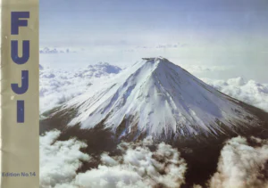 The front cover of the Fuji catalog, an aerial photograph of snow-covered Mount Fuji rising above a sea of clouds, with FUJI set vertically in blue capitals down a gold band at the left edge.