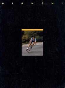 Front cover of the Bianchi catalog of about 1985: the name Bianchi in widely spaced capitals above a small photograph of a racer leaning a pale blue-green bicycle through a bend, on a near-black ground.