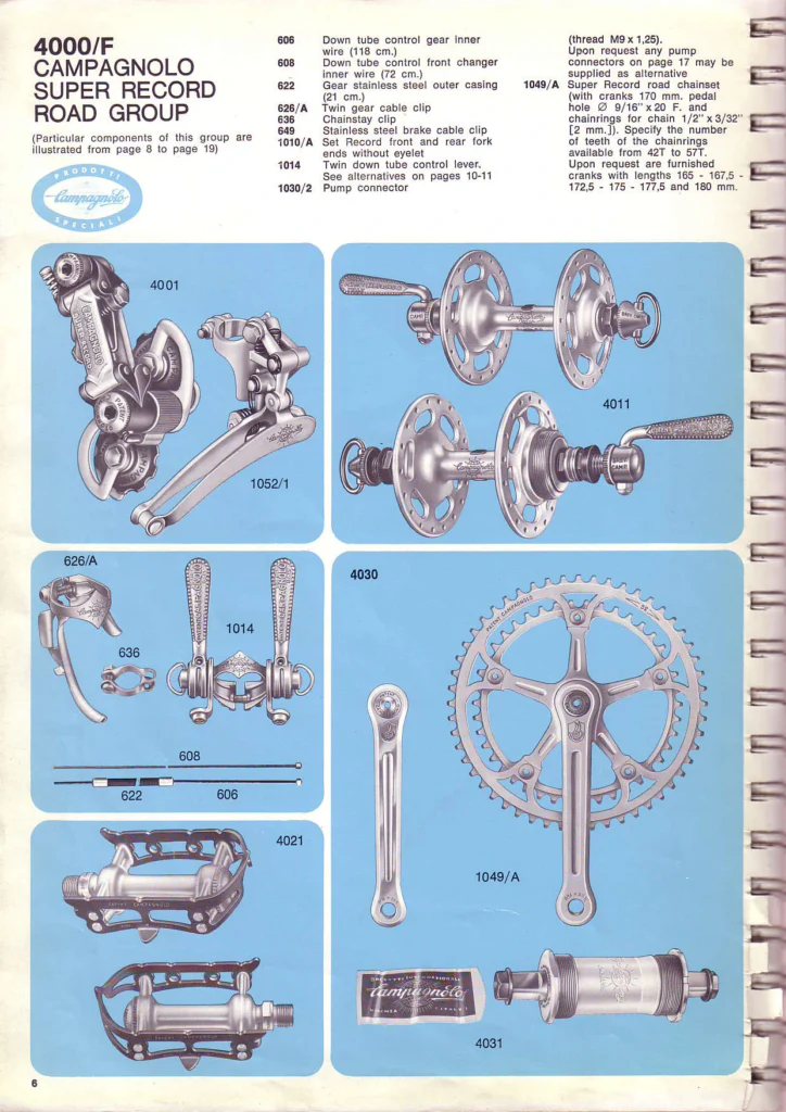 A catalog page of the Campagnolo Super Record road group photographed on light blue panels: rear derailleur and front changer, hubs, cable clips and levers, pedals, crankset and bottom bracket set.