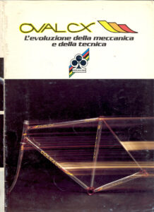 Front cover of the Colnago Oval CX folder: a chromed Oval CX frame against black with streaks of light, under the OVAL CX name and the line L’evoluzione della meccanica e della tecnica.