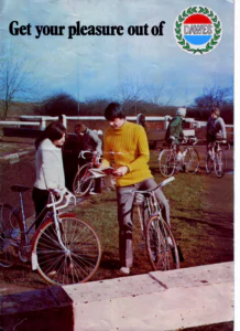 The front cover: a color photograph of five young cyclists with their bicycles beside a canal lock, under the heading and the Dawes laurel badge.