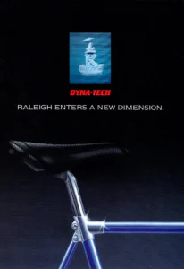 The front cover of the Raleigh Dyna-Tech brochure: a picture of the holographic Raleigh heron head badge above the Dyna-Tech name, and below it a close view of a perforated black saddle on a polished seat post and the silver seat lug of a blue frame against a dark background.